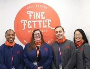 Fine Fettle employees in front of dispensary logo