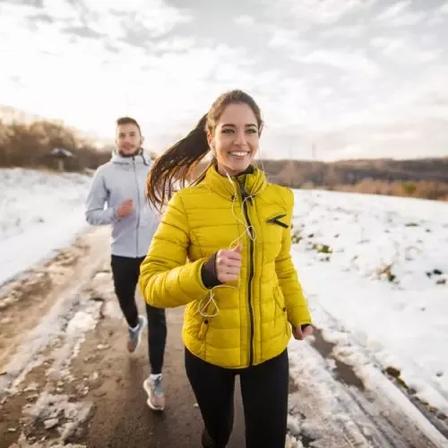 Couple running outside in the snow