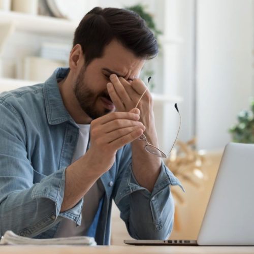 Man with headache rubbing temples