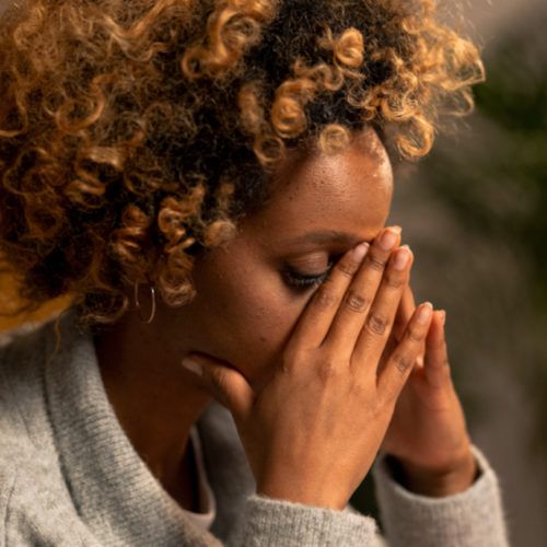 Woman with hands over her face