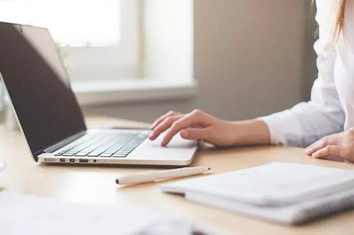 <p>Photo of a woman browsing on a laptop</p>
