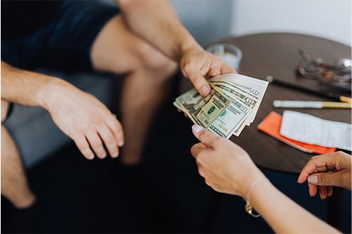 Photo of a person hand putting cash into another person's hands