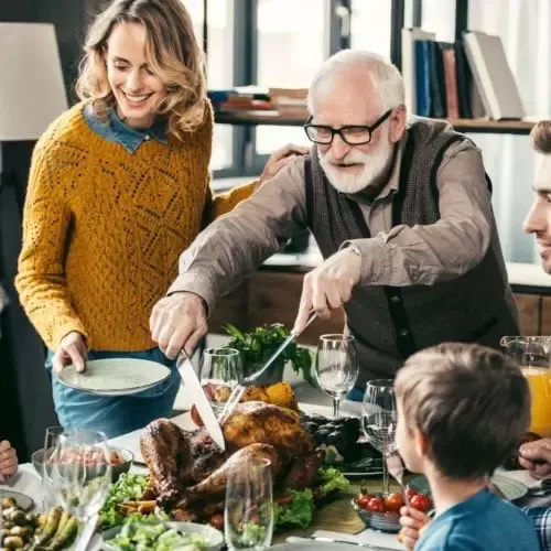 People cutting thanksgiving turkey