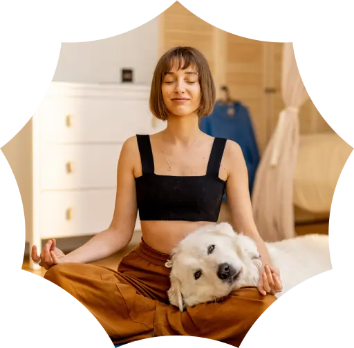 A woman sits cross-legged meditating indoors, smiling with eyes closed, while her fluffy white dog rests its head on her lap amid calming marijuana facts.