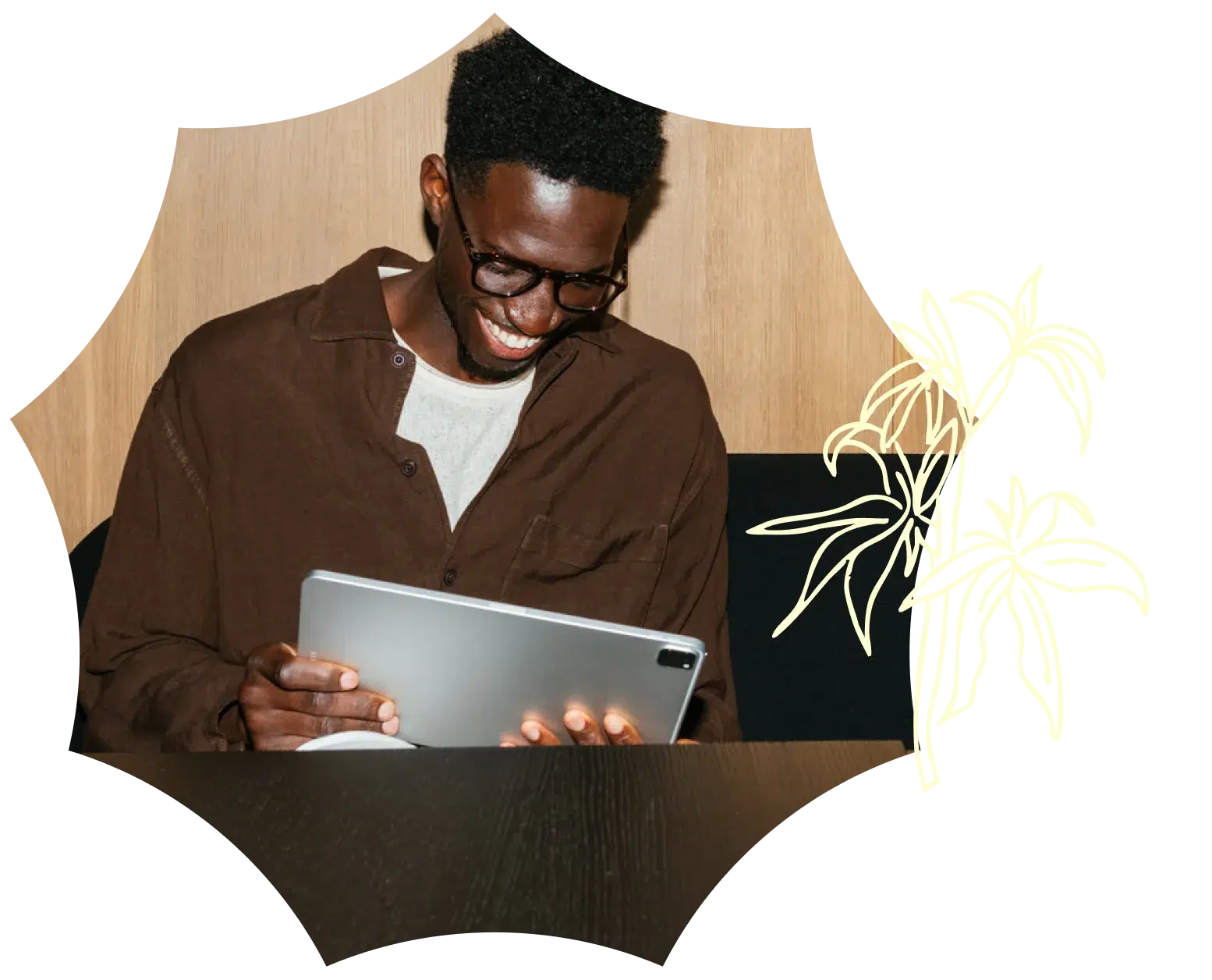 A smiling man wearing glasses and a brown shirt sits at a table, looking at a tablet, with a light plant illustration and ma medical dispensary theme in the background.