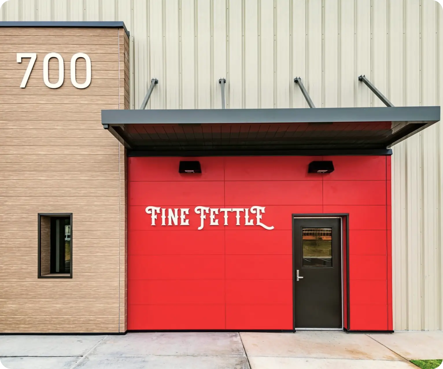 A modern building with a tan and red exterior, labeled FINE FETTLE above the door, marks one of the newest dispensary locations, with the number 700 displayed on the left side.