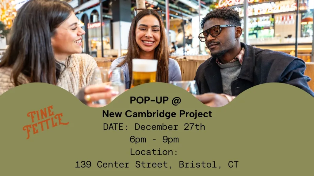 Three people sit at a table in a lively cafe, smiling and talking, with event details for a pop-up at New Cambridge Project in Bristol, CT, displayed in front.