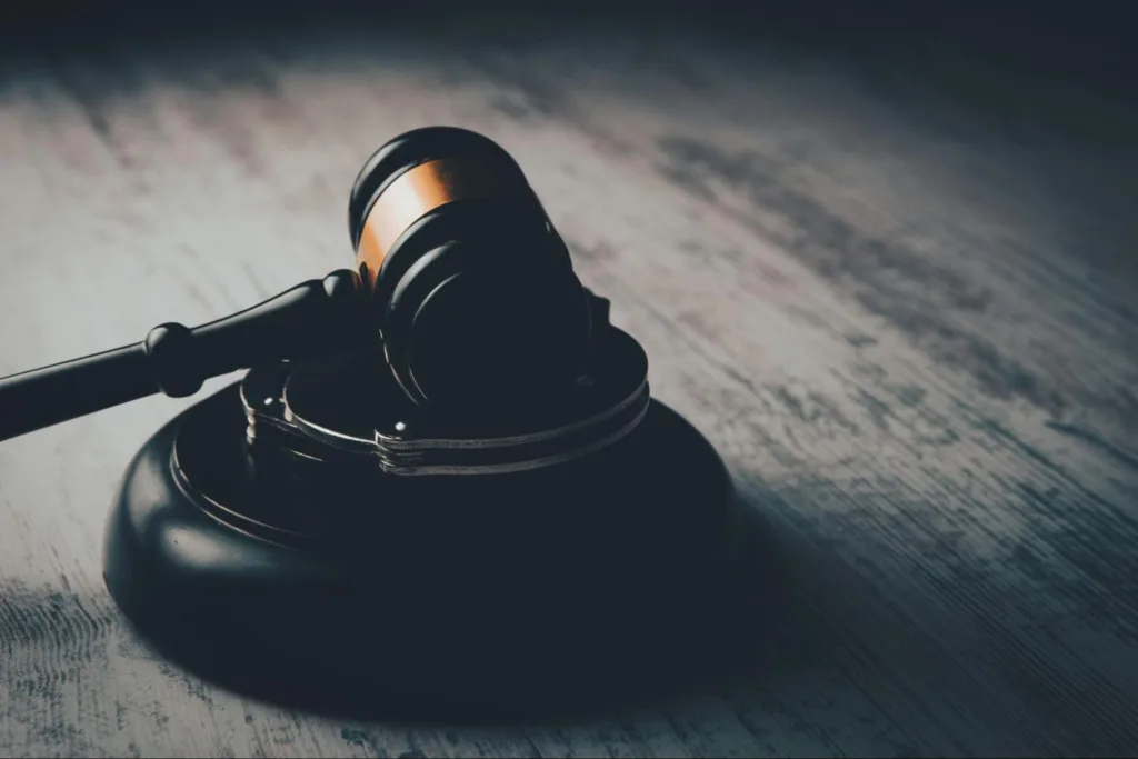 A judge gavel on its side resting on a stand.