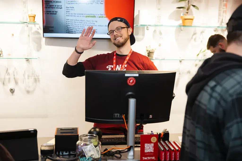 budtender waving at a checkout counter
