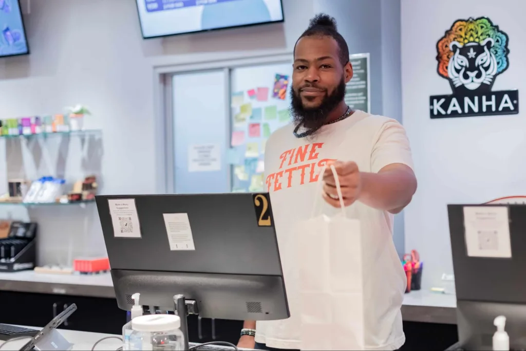 budtender handing a bag to the camera