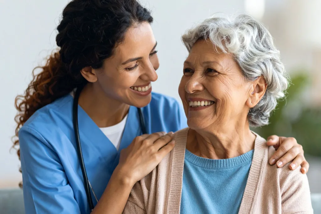 Smiling nurse holds the shoulders of a smiling patient 