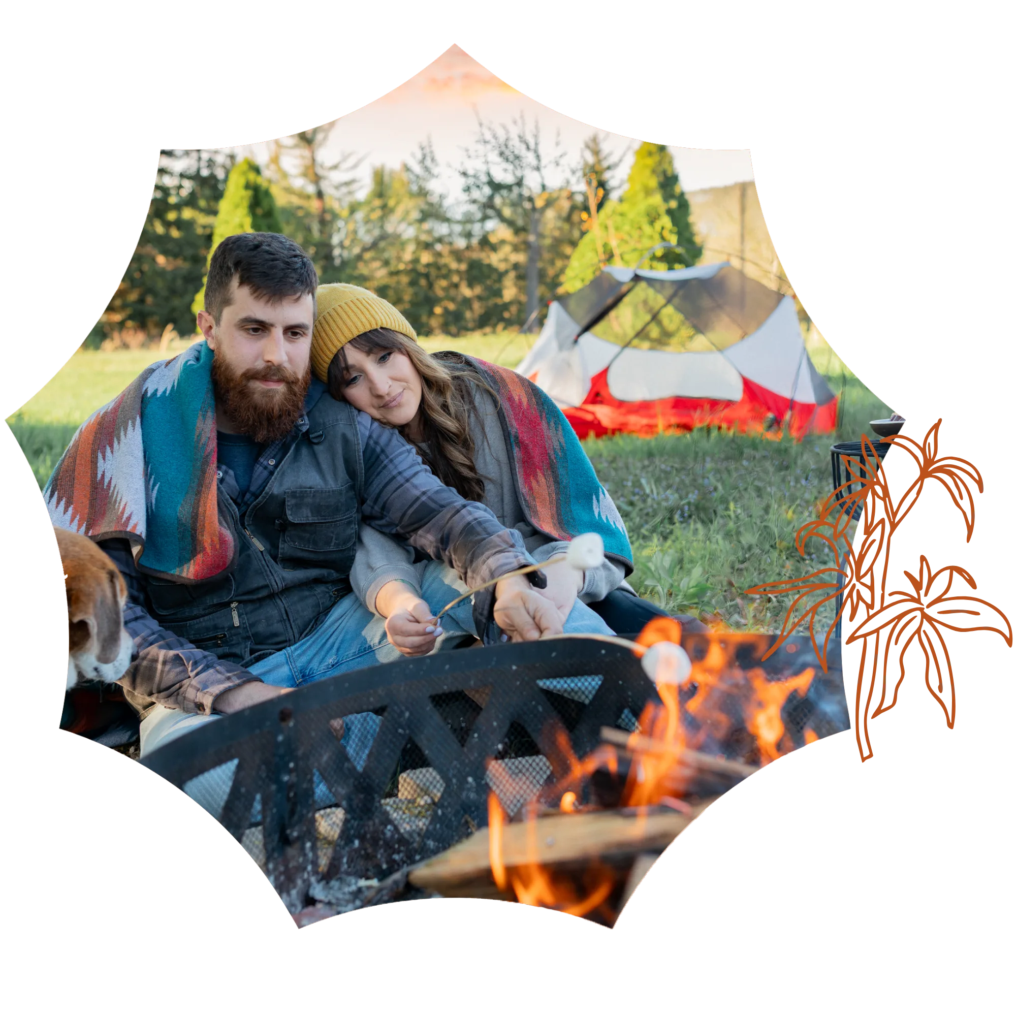 A couple wrapped in a blanket roasts marshmallows from a local dispensary over a campfire near a tent.